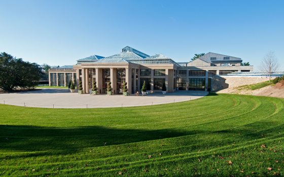 a wide shot of a green lawn with a building in the background