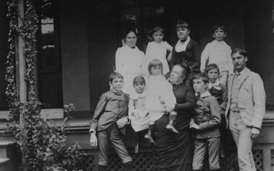 a black and white photo of a family on a porch