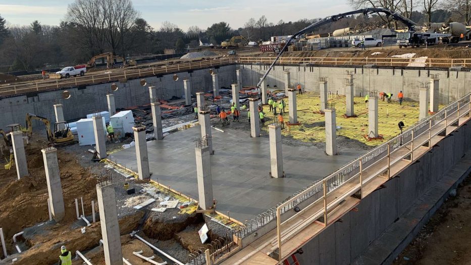 Rows of vertical concrete columns rise from a floor of rebar and freshly poured concrete