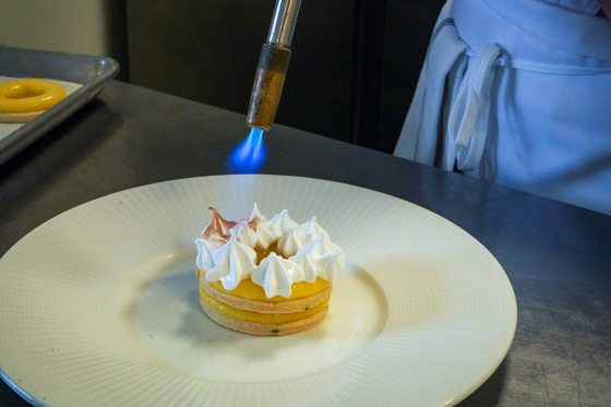 someone toasting white meringue with a torch