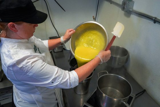 person holding a metal bowl of lemon curd