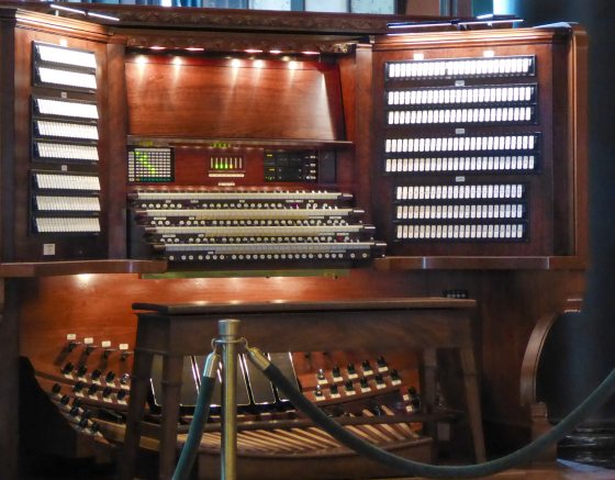 A large organ console lit up and ready to be played. 