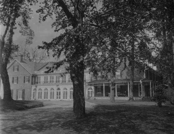 A black and white image of the exterior Peirce du Pont House at Longwood Gardens.