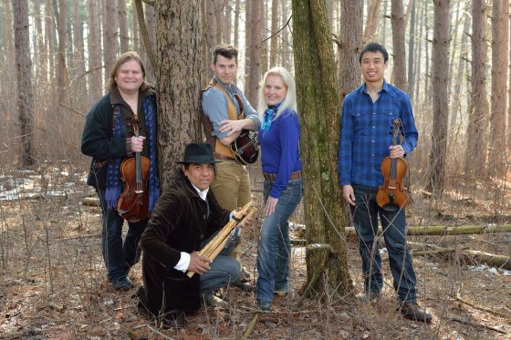 a musical group posing in front of trees 